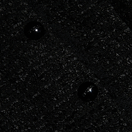 Close-up of the Nerina Tweed Blazer’s textured black tweed fabric featuring two shiny black buttons sewn in a vertical arrangement near the center.