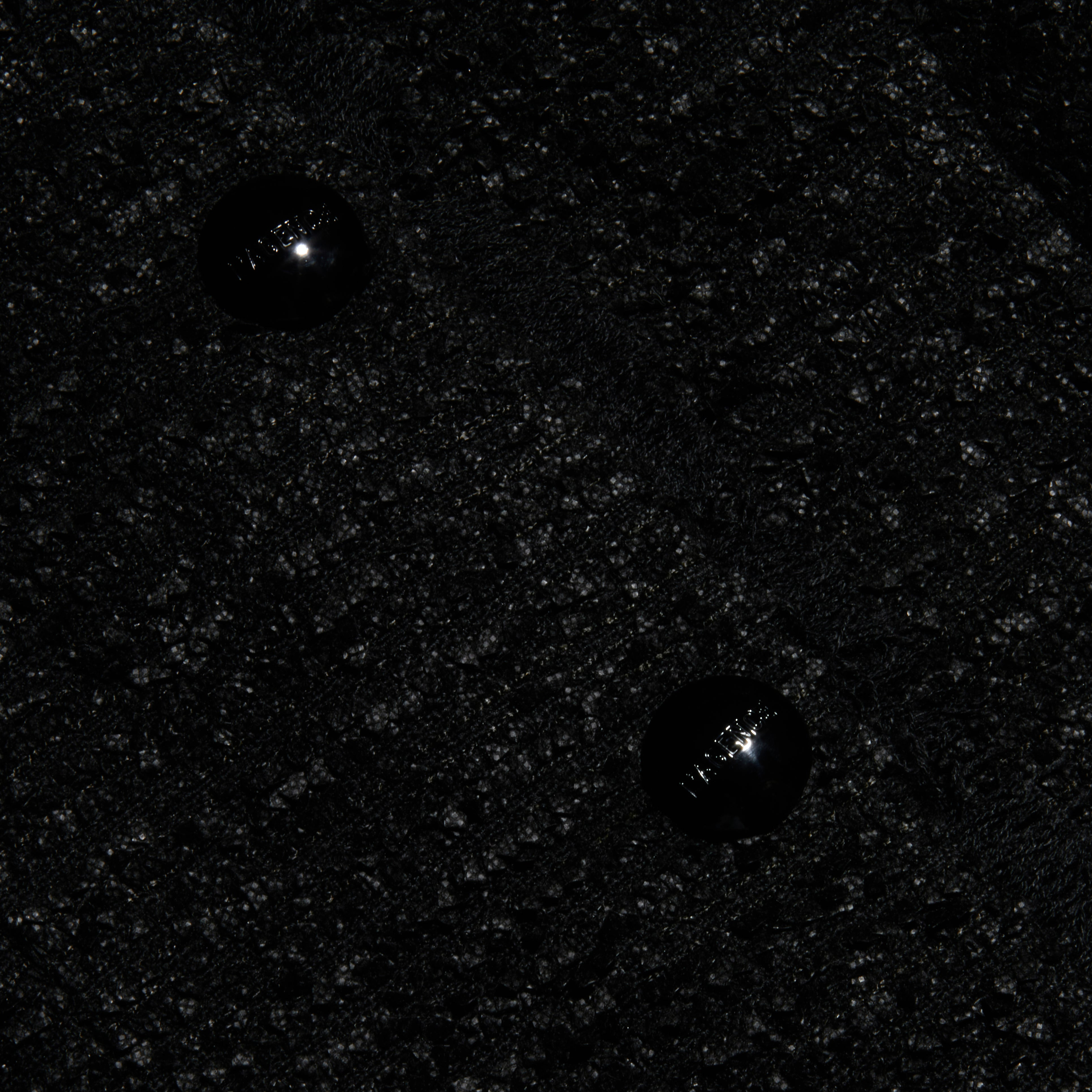 Close-up of the Nerina Tweed Blazer’s textured black tweed fabric featuring two shiny black buttons sewn in a vertical arrangement near the center.