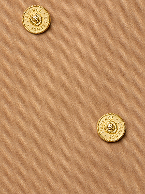 Close-up of two gold buttons embossed with 