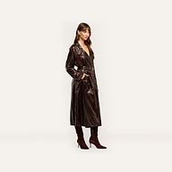 A person wearing an oversized, dark brown nylon Brinley Nylon Trench Coat with a belted waist and matching heeled boots.