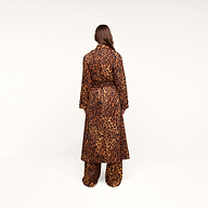A person with long brown hair, seen from behind, is wearing the Brinley Oversized Trench Coat in a matching leopard print, paired with coordinating pants against a plain white background.