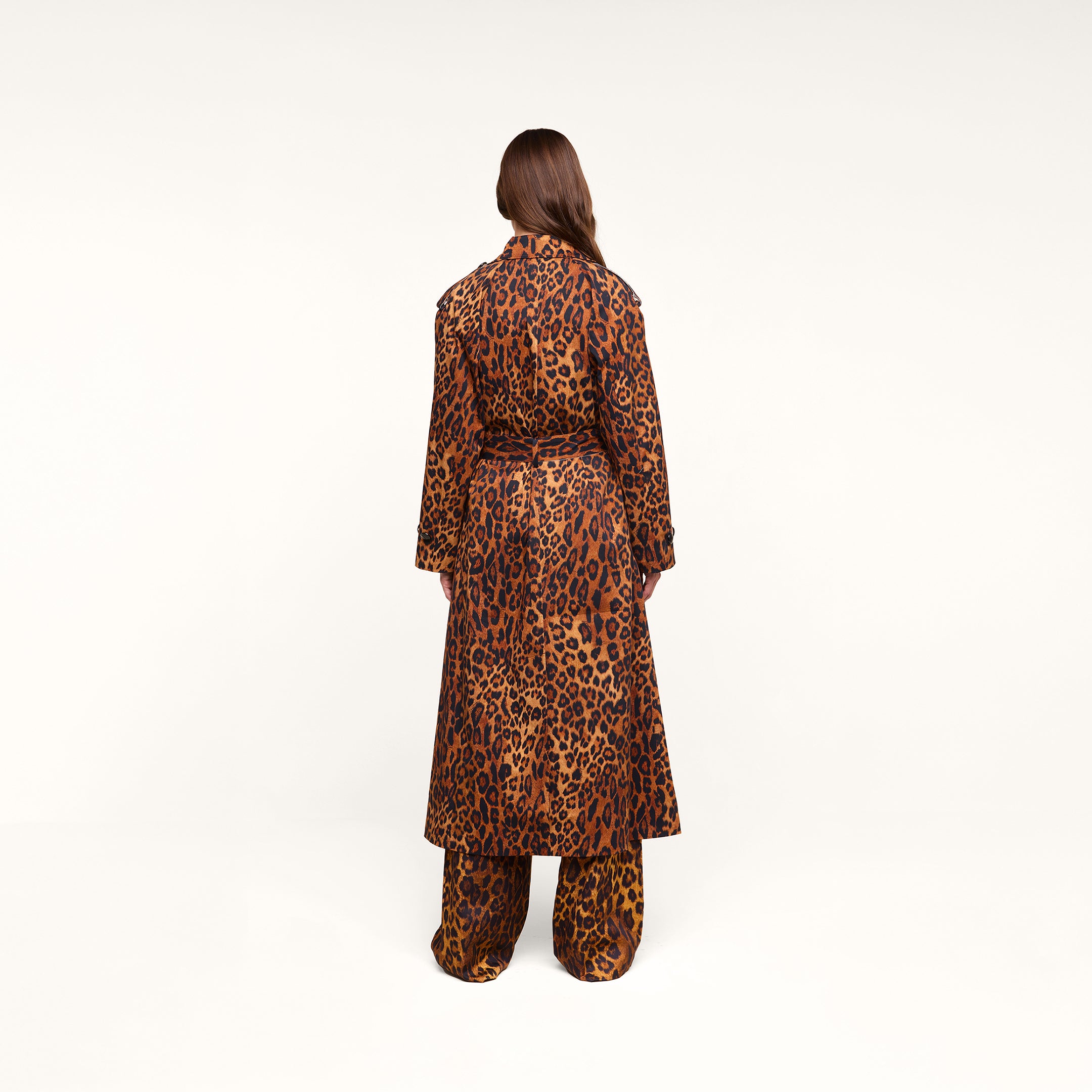 A person with long brown hair, seen from behind, is wearing the Brinley Oversized Trench Coat in a matching leopard print, paired with coordinating pants against a plain white background.