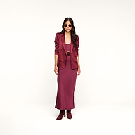 Woman wearing sunglasses, the Sena Silk Blazer in merlot red, a matching dress, and ankle boots standing against a plain white background.