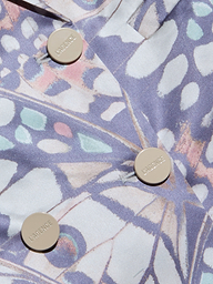 Nahaufnahme des Sena Silk Blazers, eines pastellfarbenen Zweireihers mit drei beigen LARENCE-Knöpfen. Das abstrakte Muster mischt zartes Blau, Rosa und Lavendel in organischen, blattähnlichen Formen, die von Schmetterlingsflügeln inspiriert sind.