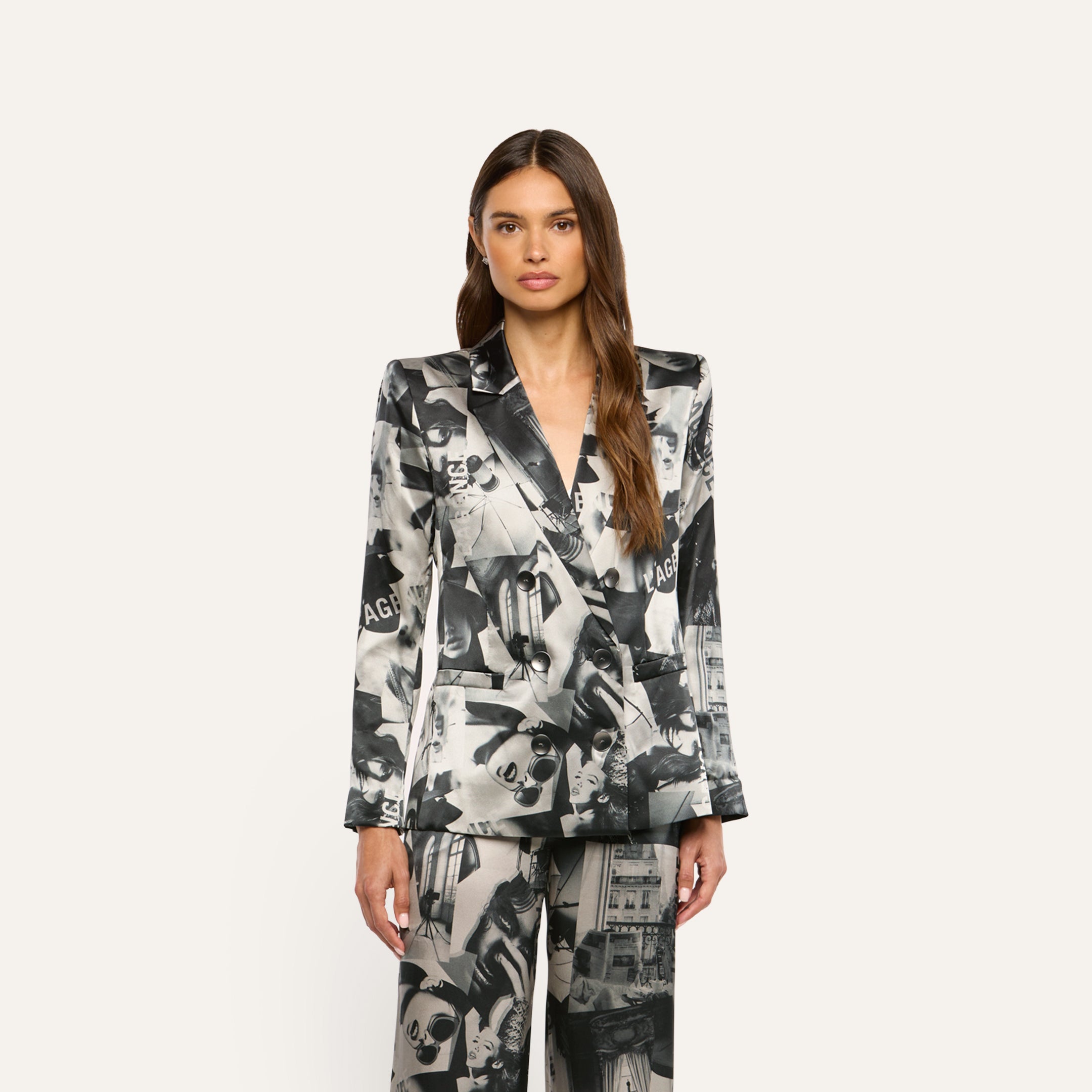 A person wearing a Sena Silk Blazer and matching trousers featuring a black-and-white collage print of text.