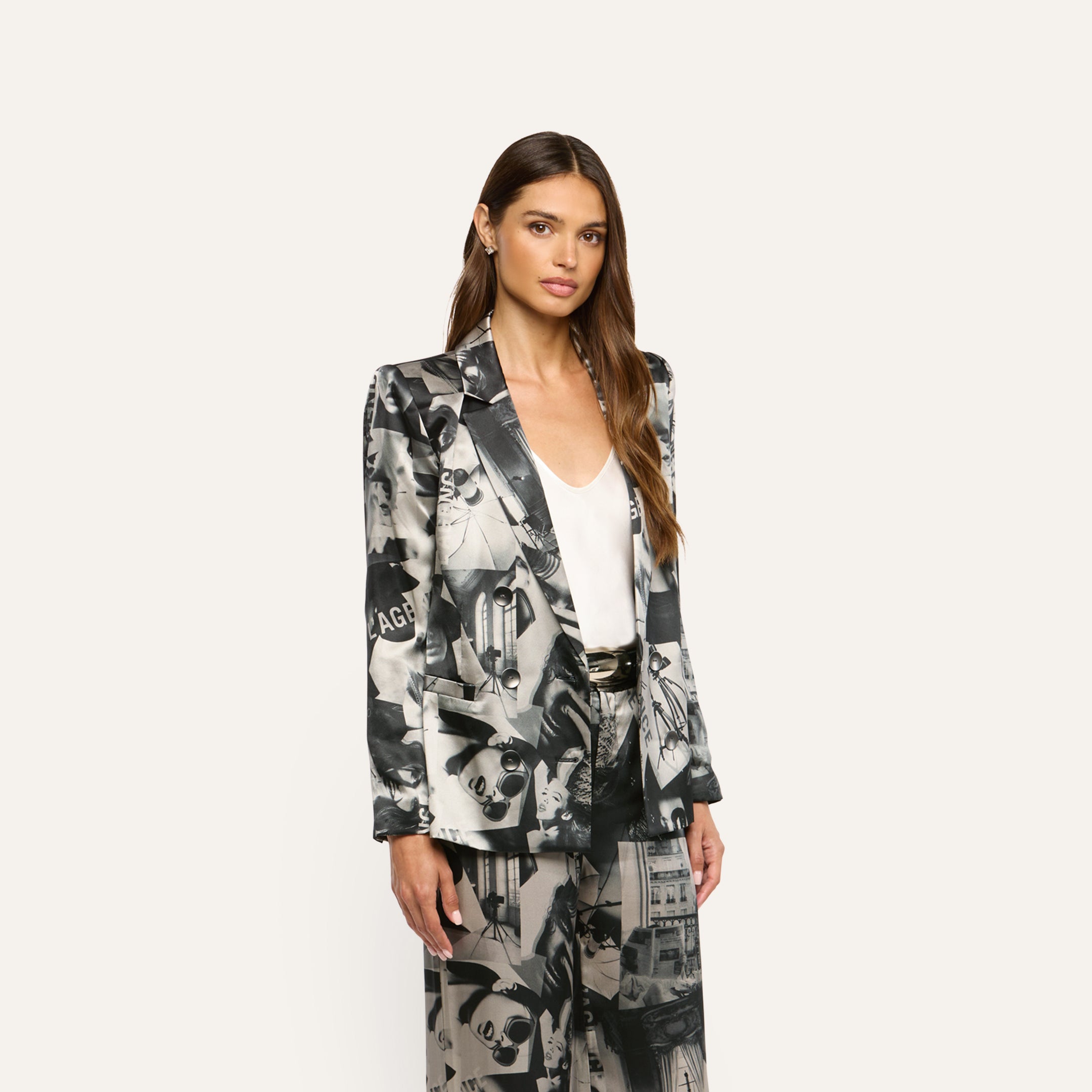 A model wears a Sena Silk Blazer and matching trousers with a black-and-white collage print over a white camisole.