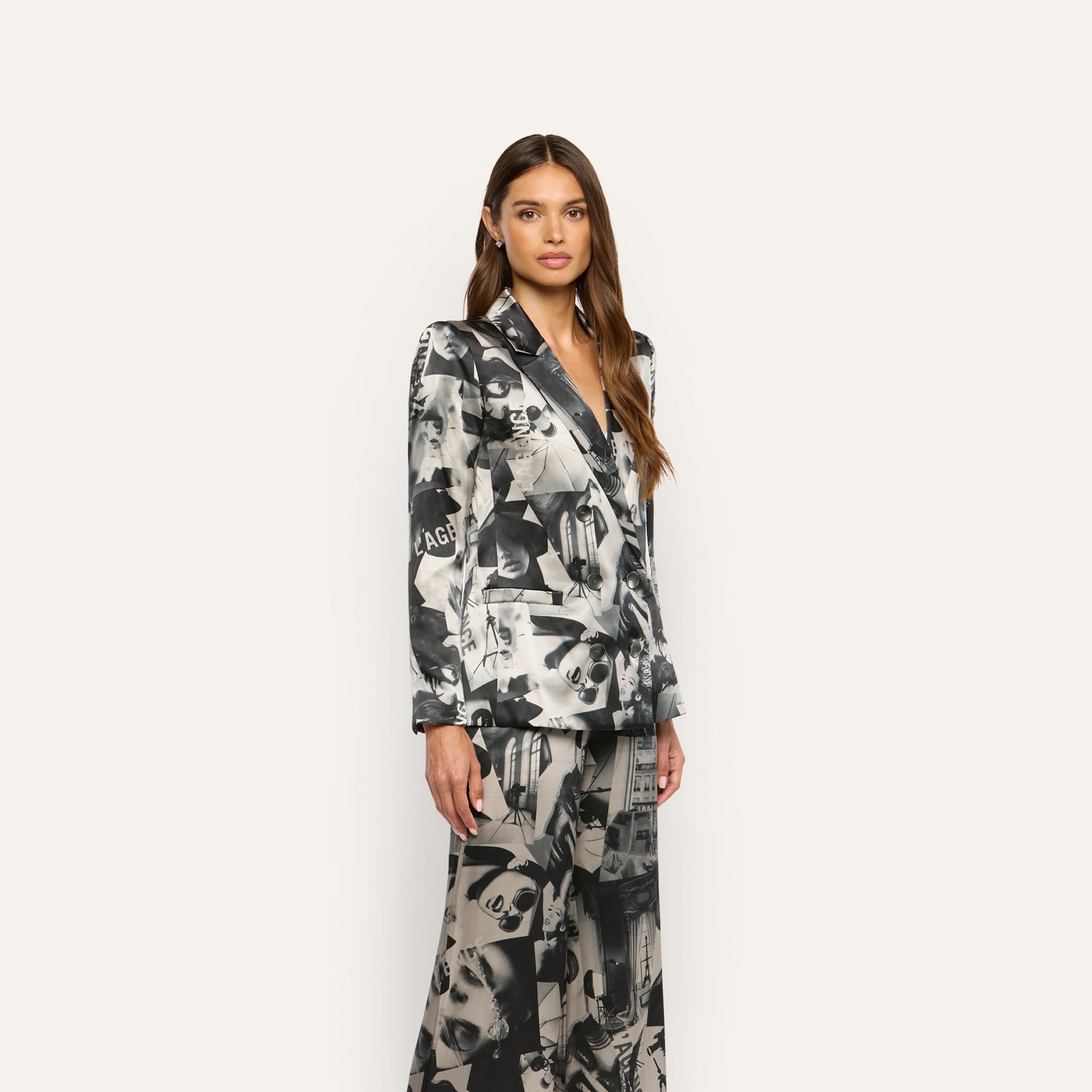 A model wears a Sena Silk Blazer and wide-leg trousers featuring a black-and-white statement print.