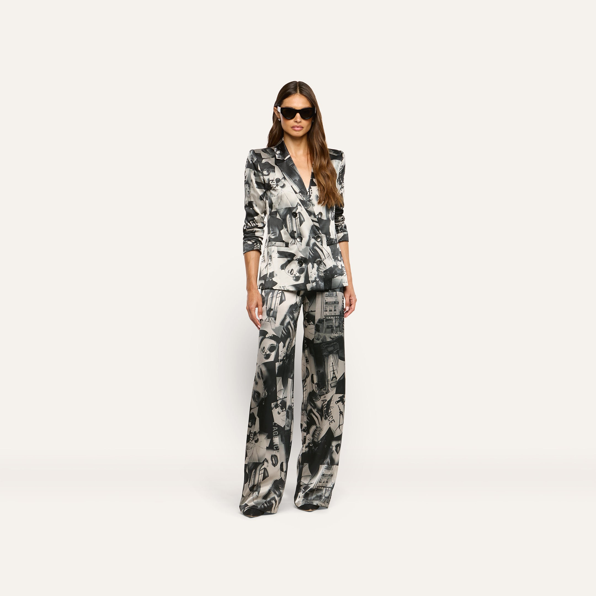 A woman wearing a Sena Silk Blazer with a statement print and matching wide-leg trousers, styled with oversized sunglasses.