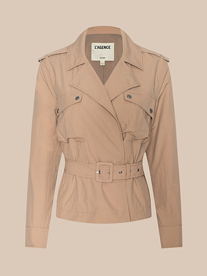 The Calida Windbreaker Trench is a belted, light tan trench coat with a collared neckline, buttoned chest pockets, and long sleeves. Made from water-repellent nylon with a LAGENCE label, it’s shown on a plain beige background.