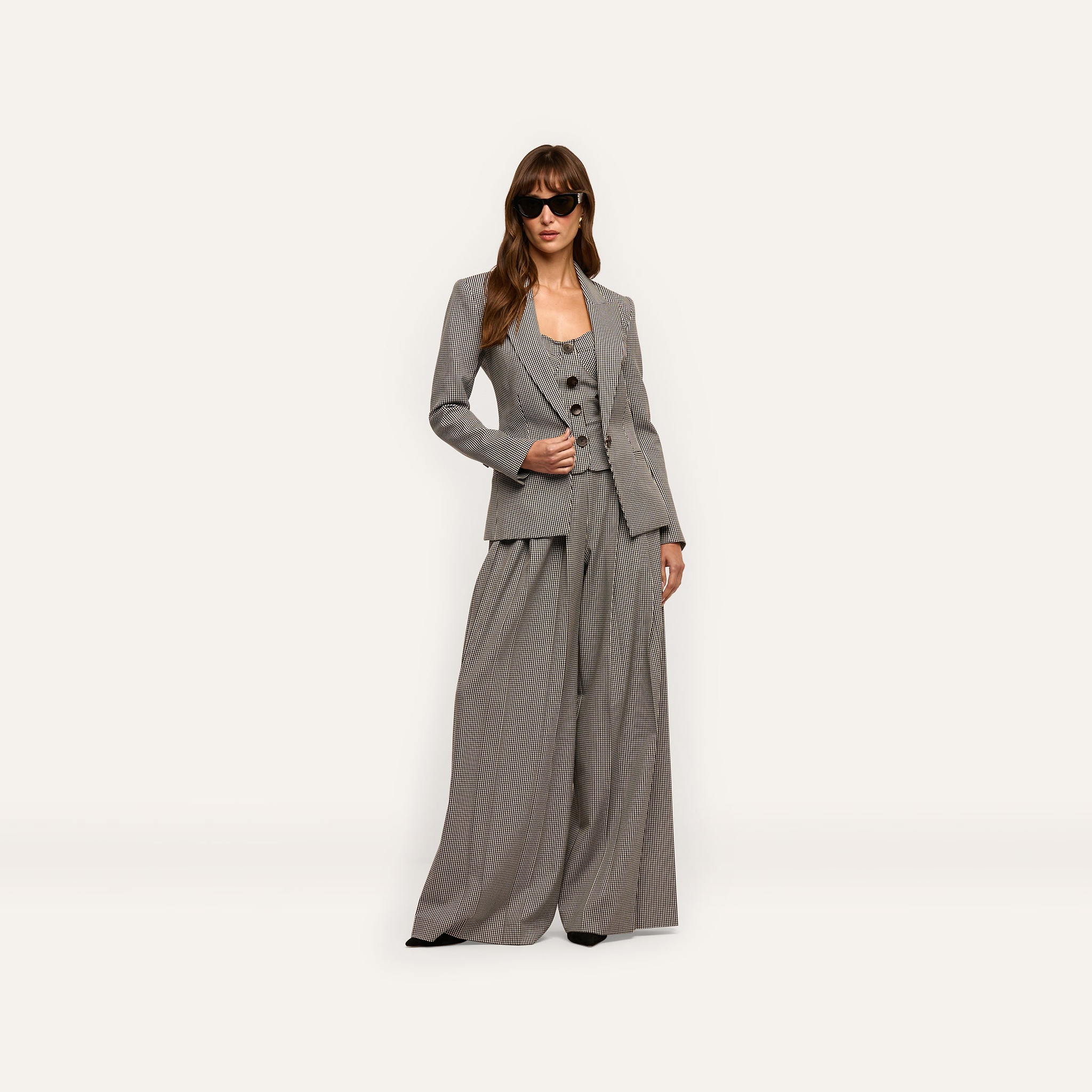 A model wearing a Blanche Blazer, button-front vest, and wide-leg trousers, styled with dark sunglasses.