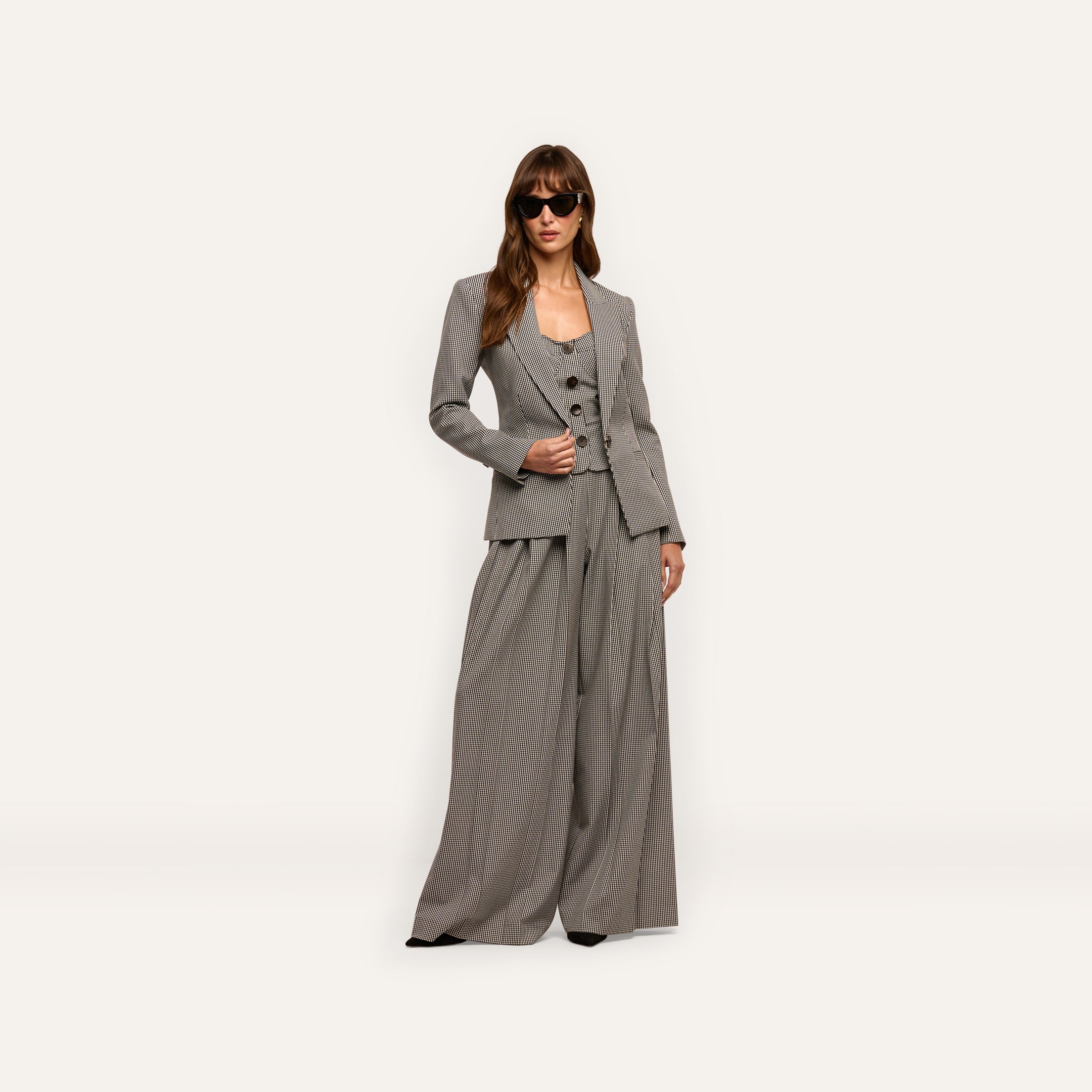 A model wearing a Blanche Blazer, button-front vest, and wide-leg trousers, styled with dark sunglasses.