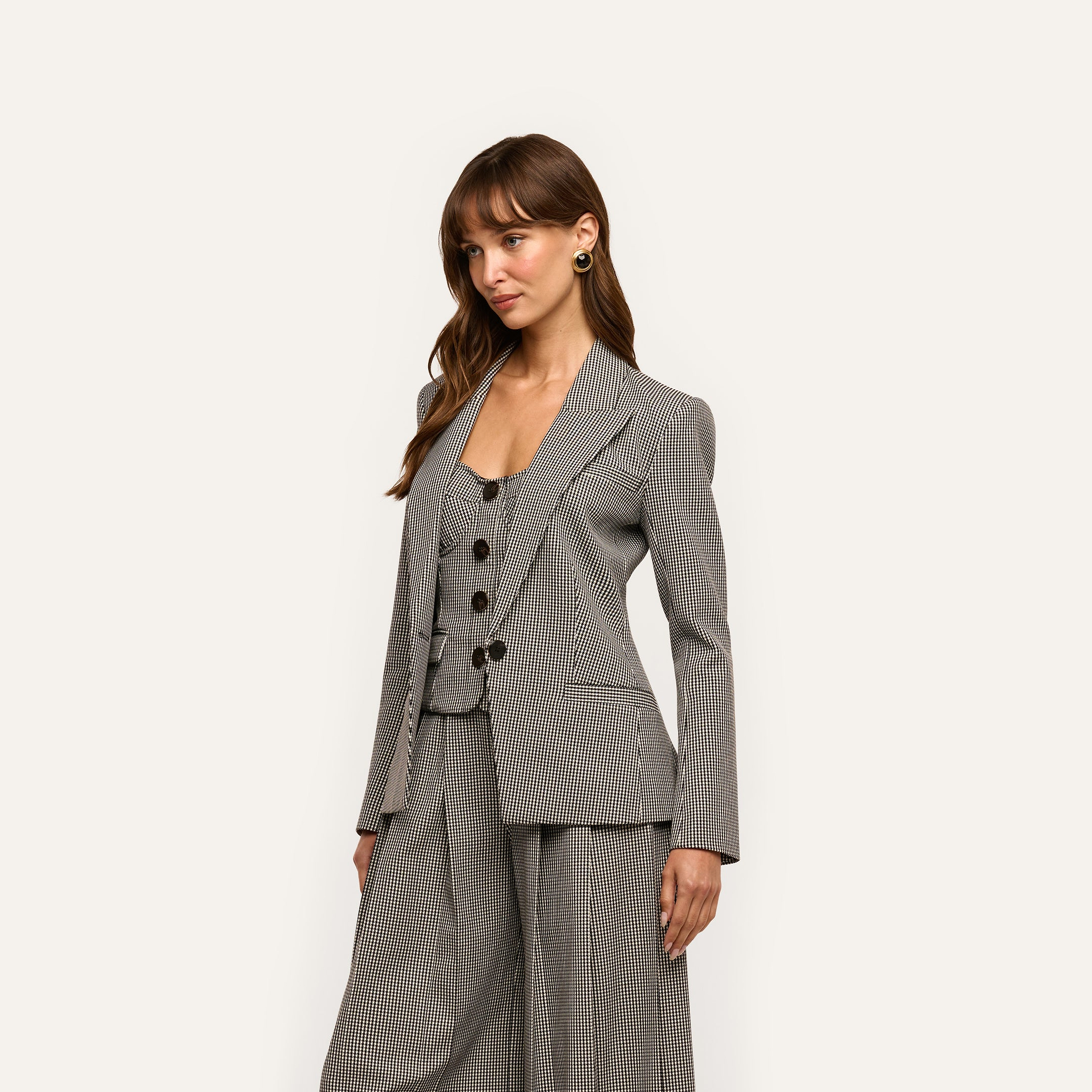 A person wearing a tailored Blanche Blazer in houndstooth over a matching buttoned vest and wide-leg trousers.