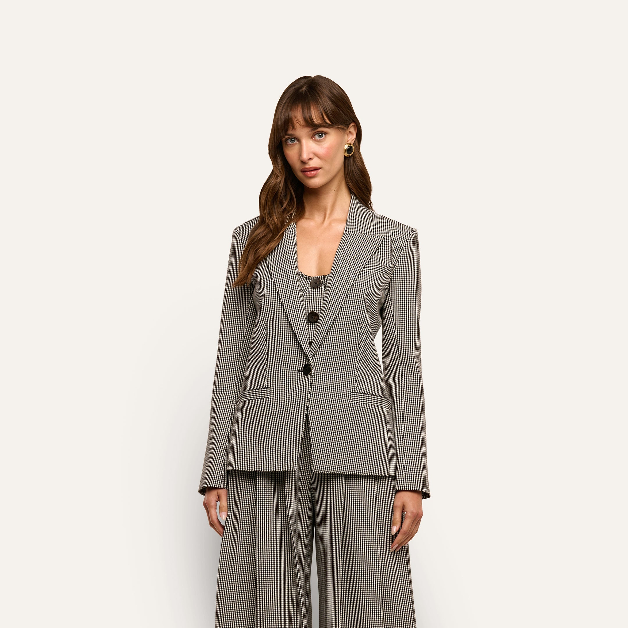 A woman wearing a Blanche Blazer over a matching button-front vest and wide-leg trousers.
