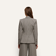 Back view of a person wearing a tailored, fitted houndstooth Blanche Blazer and matching trousers.