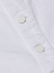 Close-up of the Kirstie Jean Shirt Jacket’s white denim fabric, highlighting two white round buttons with neatly stitched buttonholes and a subtly textured appearance.