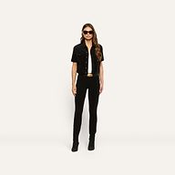 A model wearing a black velvet Kirstie Velvet Shirt Jacket over a white top and black pants, accessorized with a black belt and sunglasses.
