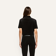 Back view of a person wearing a black Kirstie Velvet Shirt Jacket and black pants.