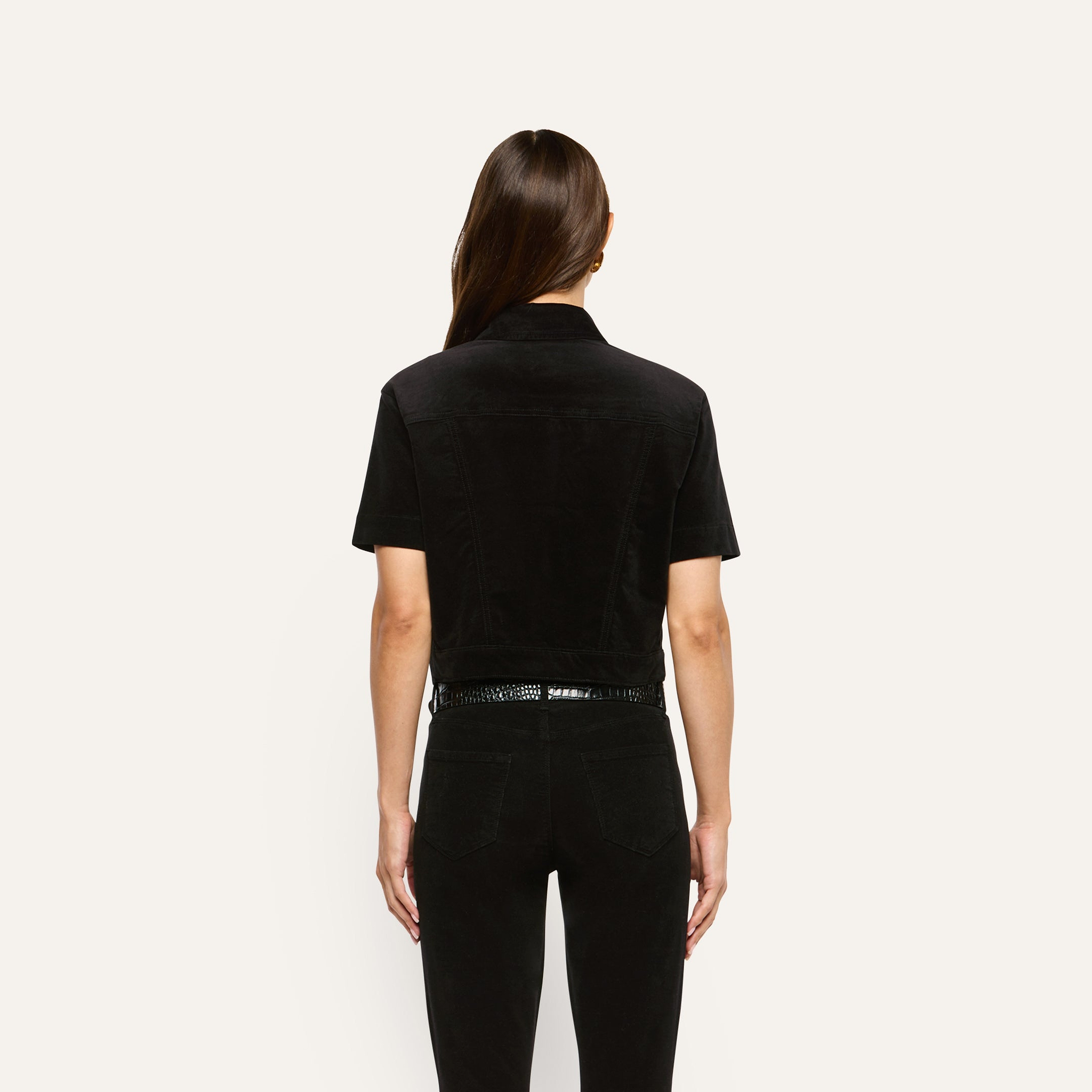 Back view of a person wearing a black Kirstie Velvet Shirt Jacket and black pants.