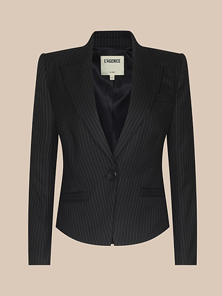 The Misa Blazer is a black pinstripe blazer for women featuring a single button closure, notched lapels, and front flap pockets, displayed on a beige background. This single-breasted blazer showcases vintage-inspired satin detailing for an elegant touch.