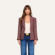 A woman wearing the Karima Tweed Blazer in red, paired with a white top and blue jeans, stands facing forward against a plain light background.