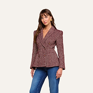 A woman wearing the Karima Tweed Blazer—a maroon herringbone double-breasted jacket with gold buttons—paired with blue jeans, stands against a plain light background.