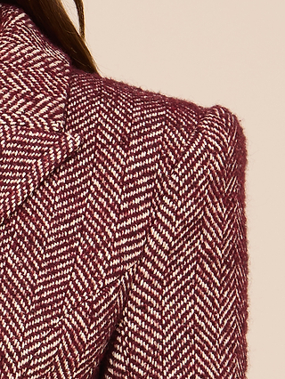 Close-up of the Karima Tweed Blazer in maroon and white herringbone on a person, focusing on the collar, lapel, and shoulder of this classic double-breasted style, with part of brown hair visible against a neutral background.