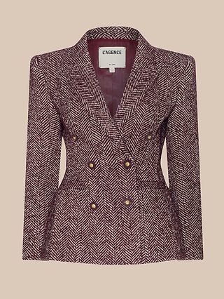 Karima Tweed Blazer in burgundy and white herringbone features a double-breasted design with gold buttons, tailored fit, and notched lapels. This sophisticated blazer has the L’AGENCE brand label visible on the inside. The background is beige.