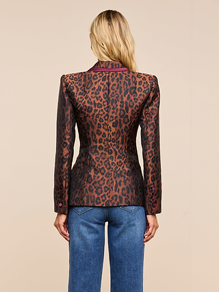 A person with long blond hair is shown from the back, wearing the Kyomi Double-Breasted Blazer and blue jeans, standing against a beige background.