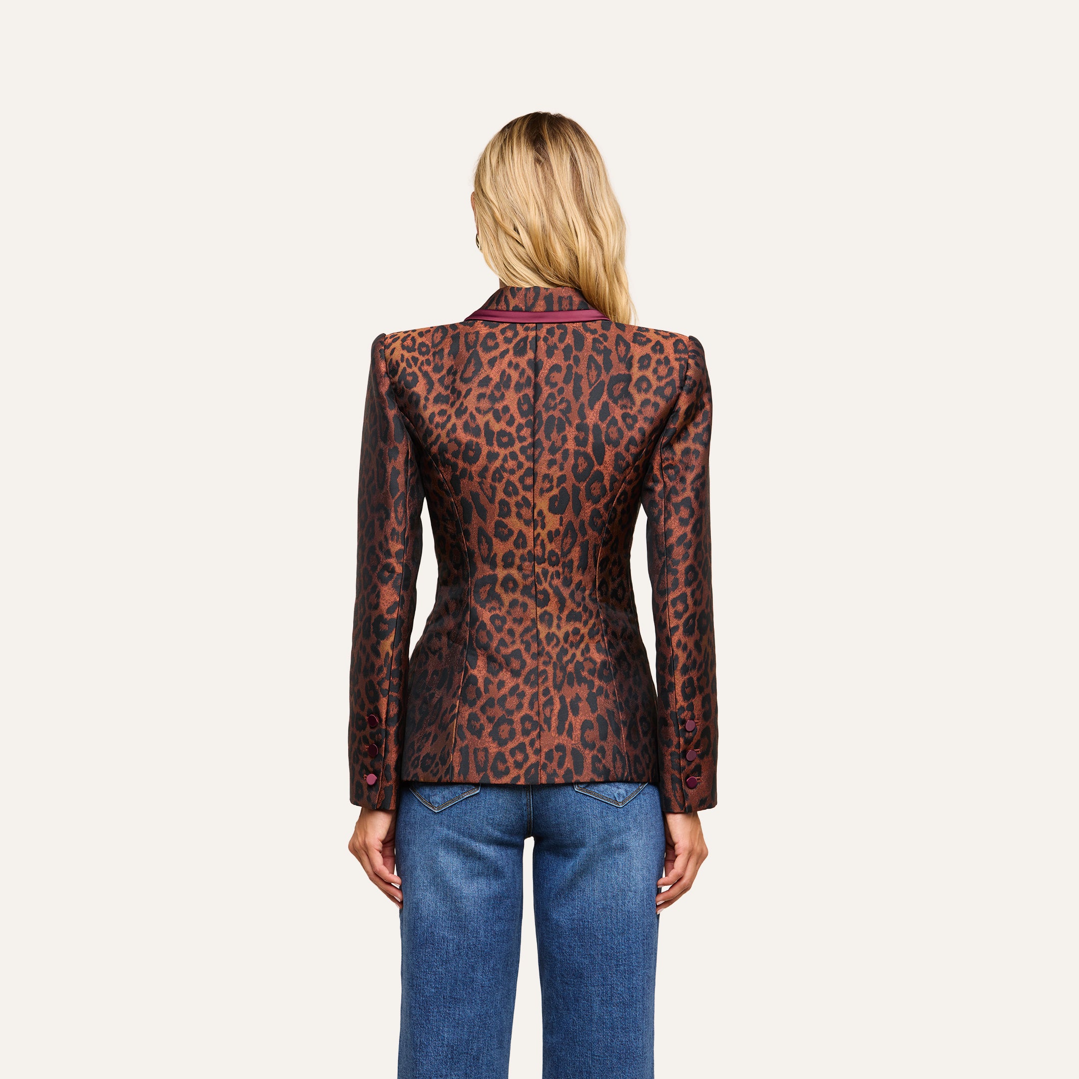 A person with long blonde hair, seen from the back, wears the Kyomi Double-Breasted Blazer with maroon trim and blue jeans against a plain light background.
