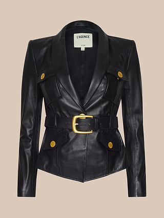 The Wisteria Leather Blazer, crafted from lightweight black leather, features gold buttons and a wide belt with a gold buckle, and is displayed on a beige background.