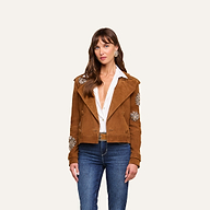 A woman stands against a plain light background, wearing the Xoey Cropped Crystal Trench Coat over a white open-collar shirt, styled with blue jeans and statement earrings, showcasing a look inspired by Fall 2026 Fashion Week.