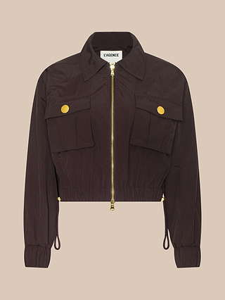 Introducing the Kade Windbreaker: a cropped, dark brown zip-up jacket featuring a collar, long sleeves, two front flap pockets with gold buttons, and an adjustable drawstring hem. This stylish windbreaker is crafted from water-repellent nylon—ideal for unpredictable weather.