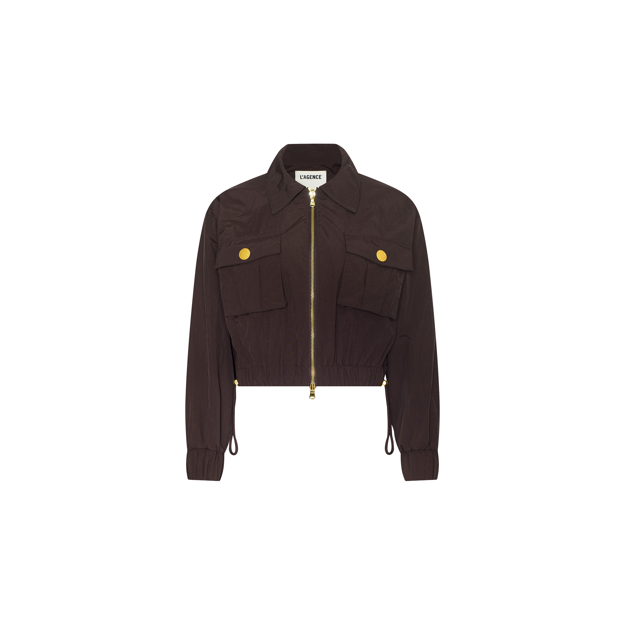 The Kade Windbreaker is a cropped nylon jacket in dark brown, featuring a front zipper, two large chest pockets each adorned with a yellow button, long sleeves, and a collared neckline, displayed against a white background.