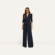 A woman wearing sunglasses and the Risa Double-Breasted Blazer with wide-leg trousers stands facing forward against a plain light background.