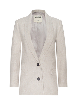 The Amlie Blazer is a light beige tailored blazer with two black buttons, front pockets, and a notched lapel, shown on a white background. Ideal for Fall 2026 or New York Fashion Week style. The label inside reads LAGENCE.
