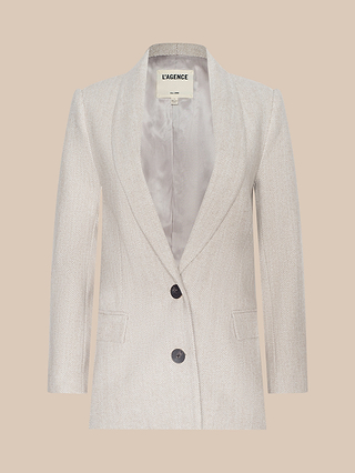 The Amelie Blazer in light beige features a sleek, fitted silhouette with a satin lining, notched lapel, two front buttons, and two front pockets. Displayed on a plain beige background, this sophisticated piece channels the elegance of New York Fashion Week style.