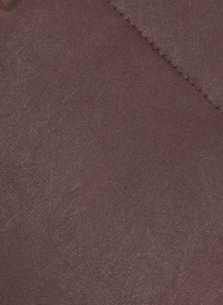 Close-up of the brown fabric from the Glacier Shawl Puffer Jacket, showcasing a visible diagonal seam and a soft, slightly textured surface.