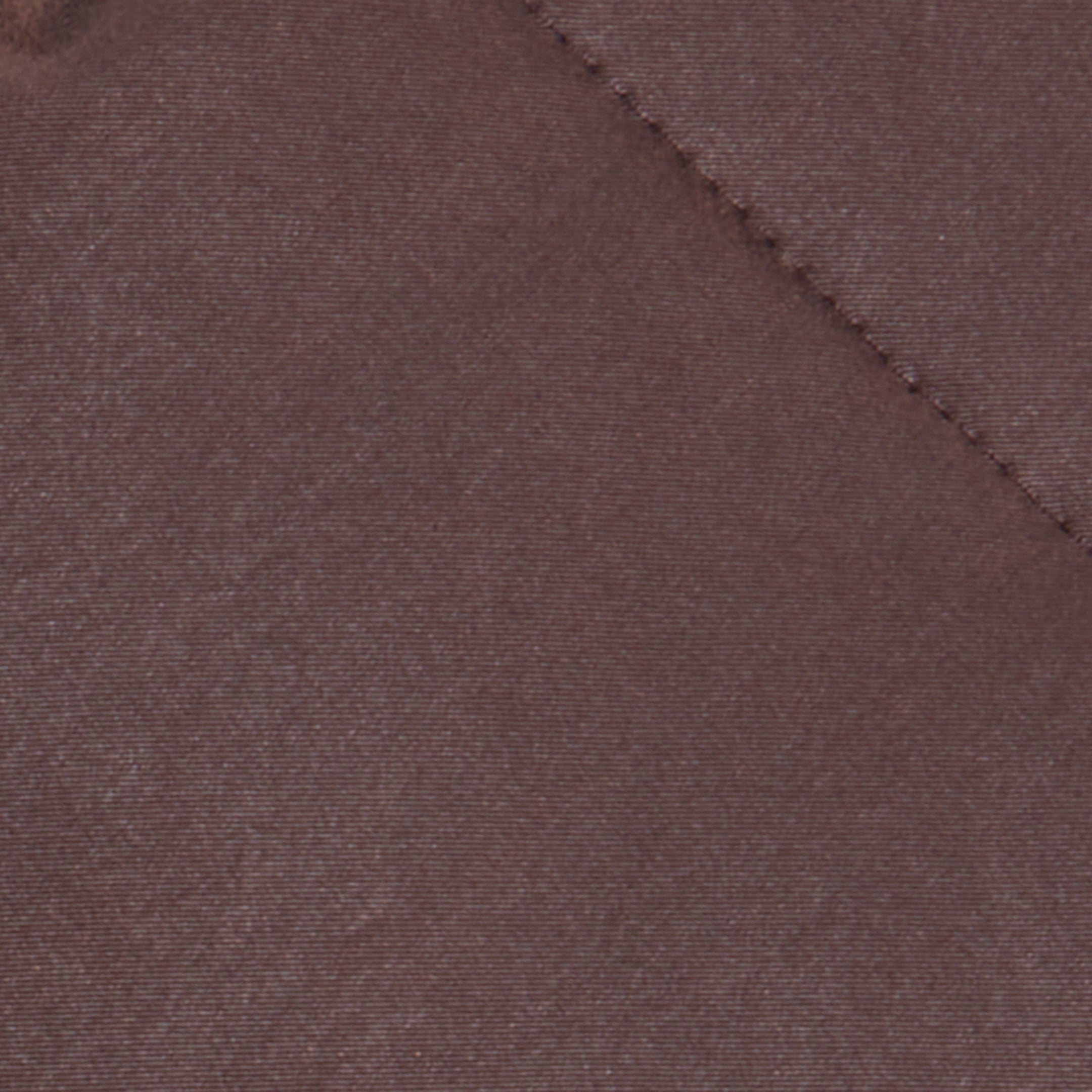 A close-up of the Glacier Shawl Puffer Jacket’s brown quilted fabric, featuring visible stitching that forms a diagonal line across the image.