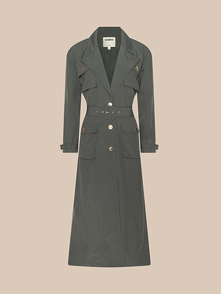 Axel Windbreaker Trench in dark green, featuring a belted waist, large front pockets, button accents, and a lapel collar in a classic utility jacket style, displayed on a light beige background.