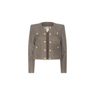 The Kahlia Jacket is a gray cropped piece with long sleeves, featuring gold decorative buttons arranged in two vertical rows on the front. Crafted from lurex tweed, this structured and tailored design evokes quiet luxury and is displayed on a plain white background.