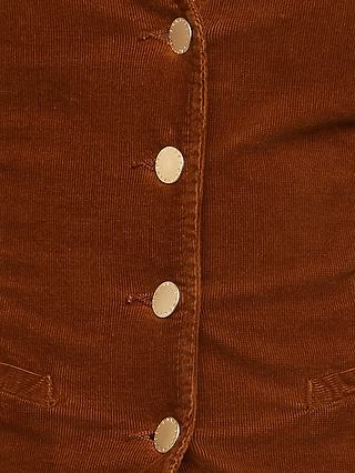 Close-up of the Yelena Vest, featuring brown stretch corduroy fabric with five gold buttons in a vertical row and two small horizontal pockets near the bottom, showcasing the refined details of this casual tailored vest.