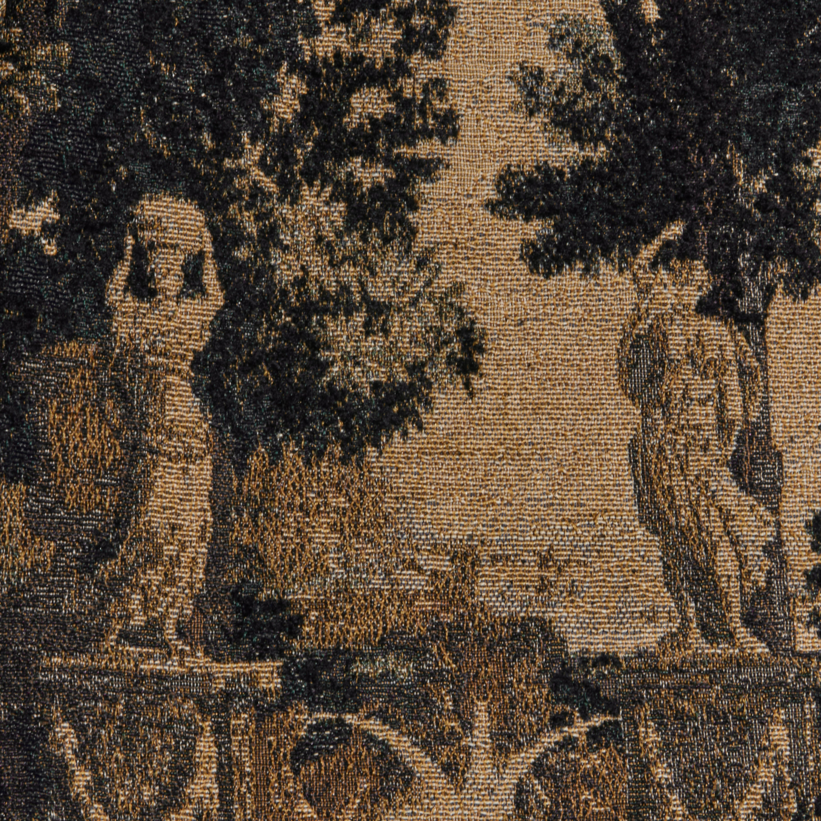 A close-up of the Lian Tapestry Jacket highlights an owl motif on the left and a small statue on the right, set against trees and a scenic background in muted brown and beige tones.