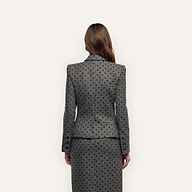 A person viewed from behind wearing a grey polka-dot Odile Blazer with notched lapels and a matching skirt.
