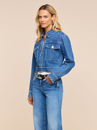 A woman with long blonde hair wears the Micah Oversized Jean Jacket, paired with matching jeans, standing against a plain beige background and looking slightly to her left.