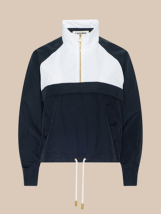 Vex Cropped Windbreaker: A long-sleeve pullover windbreaker featuring a white top half and black bottom half, gold zipper, high collar, and adjustable drawstrings at the waist. Displayed against a beige background.