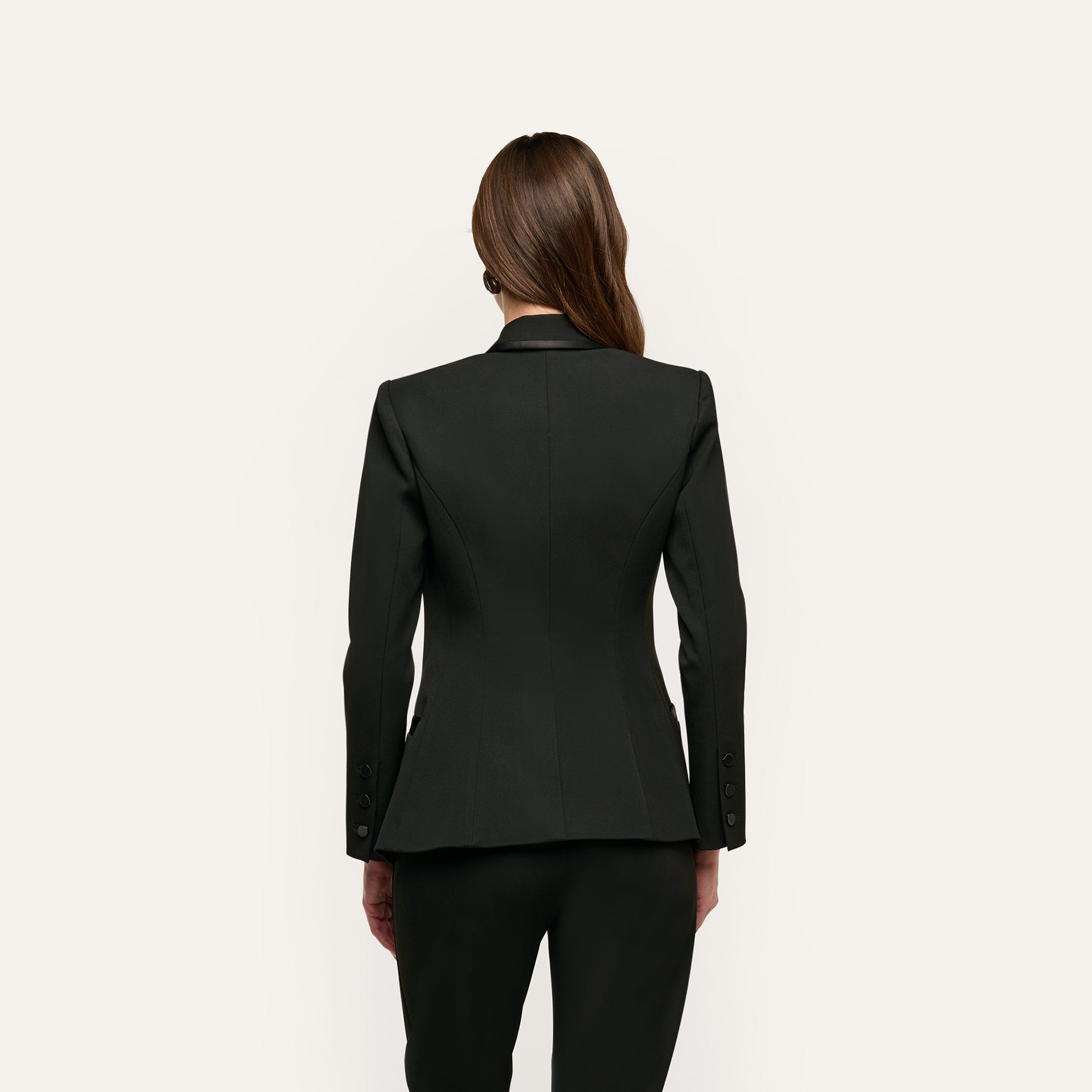 Back view of a person wearing a tailored black double-breasted Kyomi Double-Breasted Blazer in stretch suit fabric.