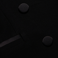 Close-up of the black Kyomi Double-Breasted Blazer showing two fabric-covered buttons and a satin-trimmed lapel in tailored stretch suit fabric.