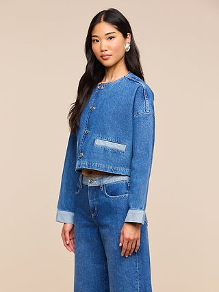 A woman with long dark hair wears the Verona Jean Jacket and matching high-waisted jeans, standing against a plain beige background.