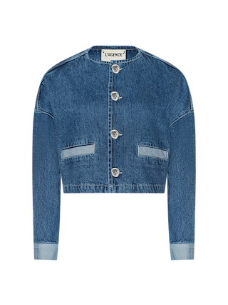 Cropped blue denim jacket with long sleeves, front buttons, two front pockets, and a visible LAGENCE label on the collar—an ideal warm weather essential to layer over the Arabell Romper or pair with a statement horseshoe print.