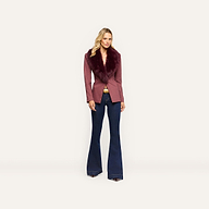 A woman wearing a Sheila Blazer in pinstripe with a large, dark-red faux fur collar and dark wash flare jeans.
